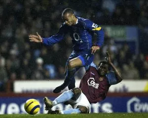 Aston Villas Djemba Djemba möter Thierry Henry i en närkamp.