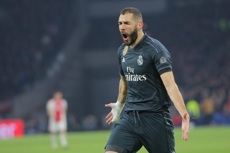 Real Madrid forward, Karim Benzema, celebrates the goal during a UEFA Champions League match playoff 1/8 finals game against Ajax