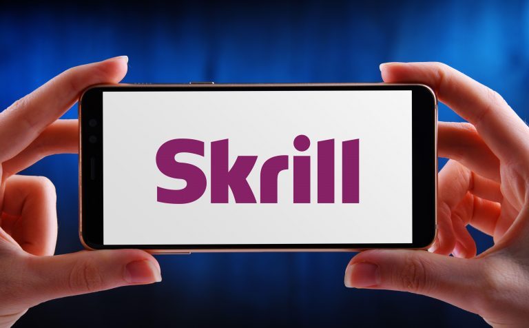 POZNAN, POL - MAY 21, 2020: Hands holding smartphone displaying logo of Skrill (formerly Moneybookers), an e-commerce business that allows payments an